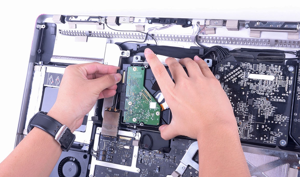 Infotech technician repairing Mac computer.